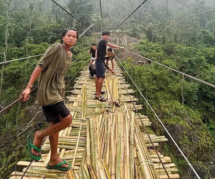 Villagers rebuilding Beging hanging bridge